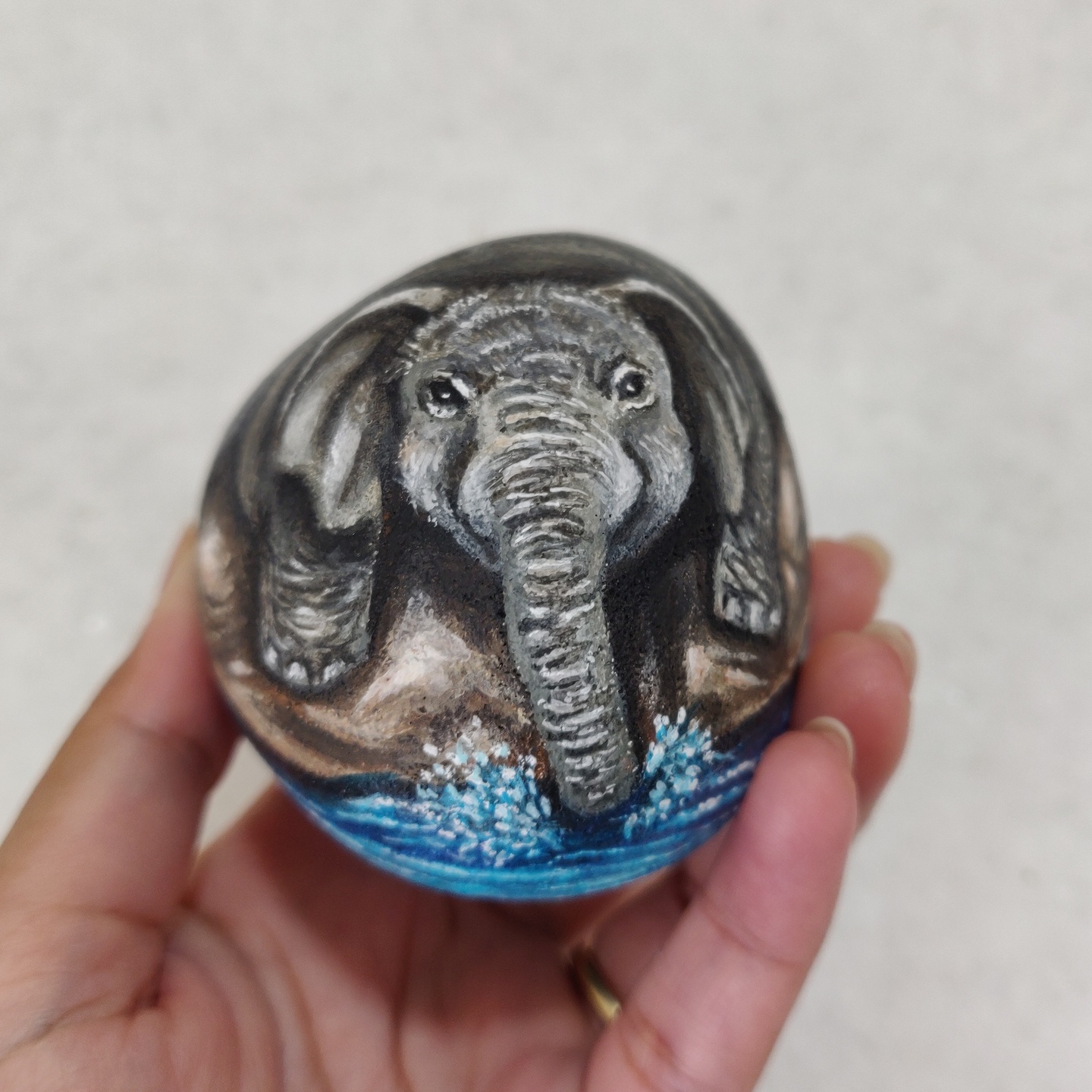 Baby elephant splashing on a rock, hand painted on a rock for elephant lovers