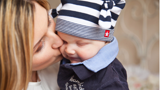 Canva - Woman in White Shirt Kissing Baby With Black and White Stripe Knit Cap.jpg